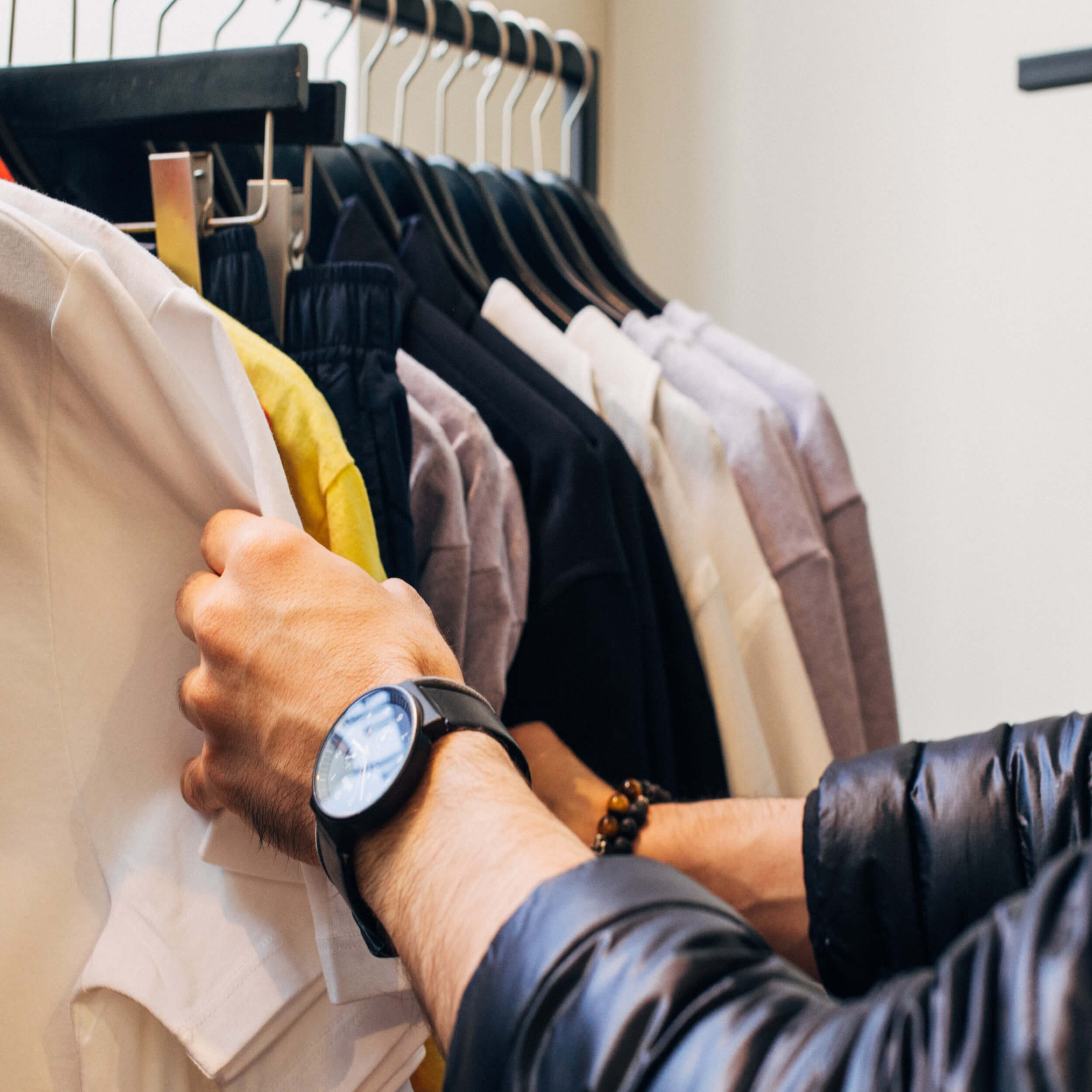 someone choosing a garment from a rail of clothes